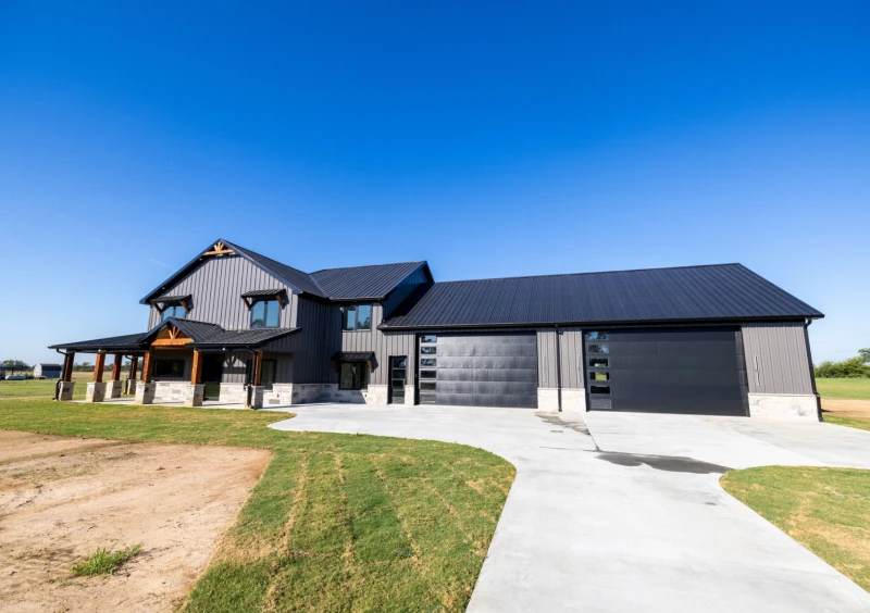 Modern farmhouse with large garage and driveway.